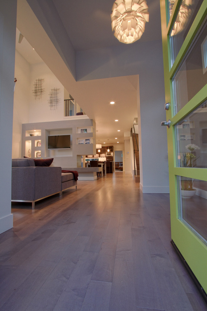 Réalisation d'un hall d'entrée minimaliste de taille moyenne avec un mur gris, un sol en bois brun, une porte simple et une porte verte.