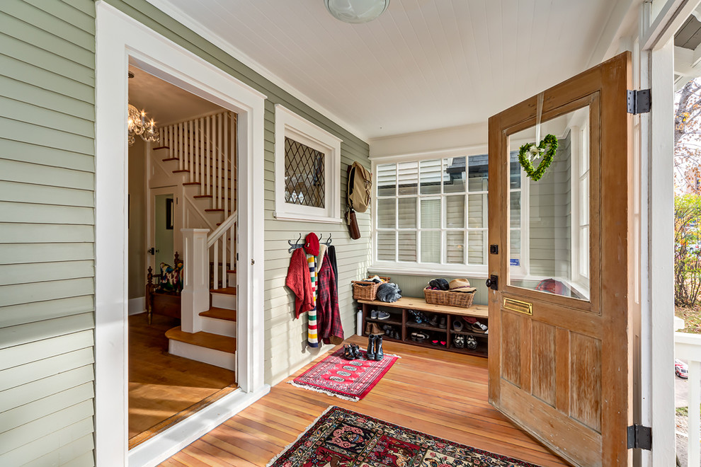 Modelo de vestíbulo de estilo de casa de campo de tamaño medio con paredes verdes, suelo de madera en tonos medios, puerta simple y puerta de madera en tonos medios