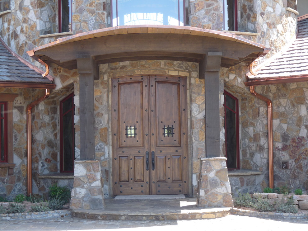 Cette image montre une très grande porte d'entrée traditionnelle avec un mur beige, un sol en travertin, une porte simple et une porte en verre.