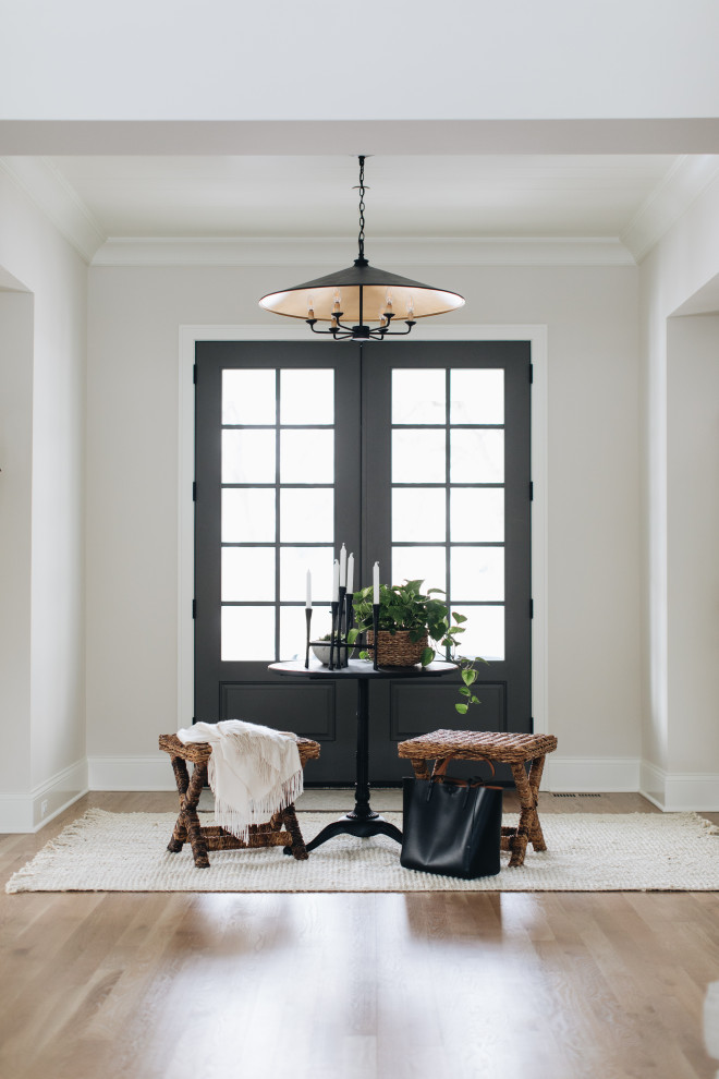 Country medium tone wood floor and brown floor entryway photo in Chicago with beige walls and a black front door