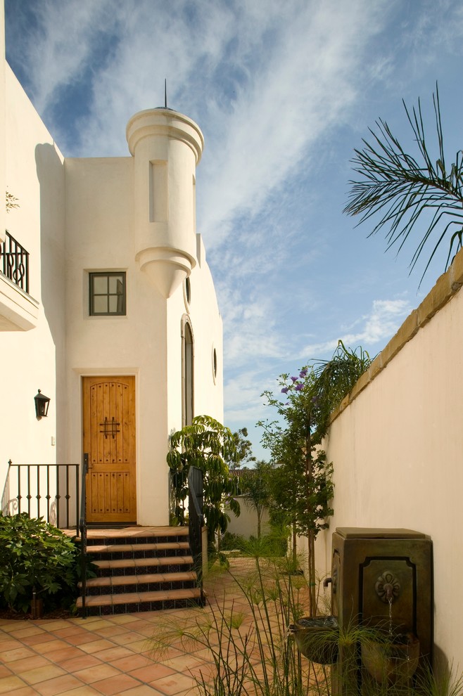 Kleine Mediterrane Haustür mit weißer Wandfarbe, Terrakottaboden, Einzeltür und hellbrauner Holzhaustür in Santa Barbara
