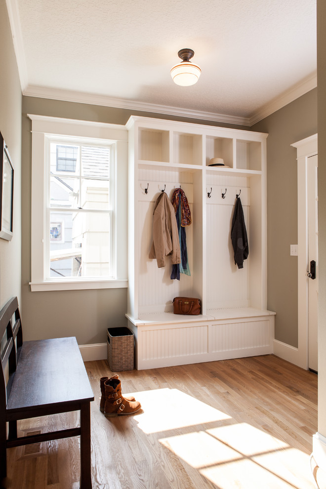 Classic boot room in Portland with a white front door, grey walls and feature lighting.