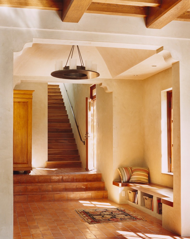 サンフランシスコにある高級な小さな地中海スタイルのおしゃれな玄関ホール (ベージュの壁、テラコッタタイルの床、木目調のドア) の写真