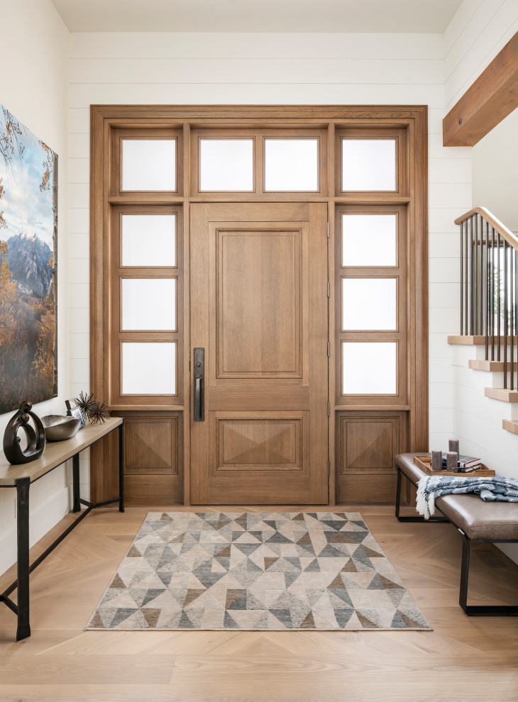 This is an example of an expansive country front door in Salt Lake City with white walls, light hardwood flooring, a single front door, a medium wood front door and beige floors.