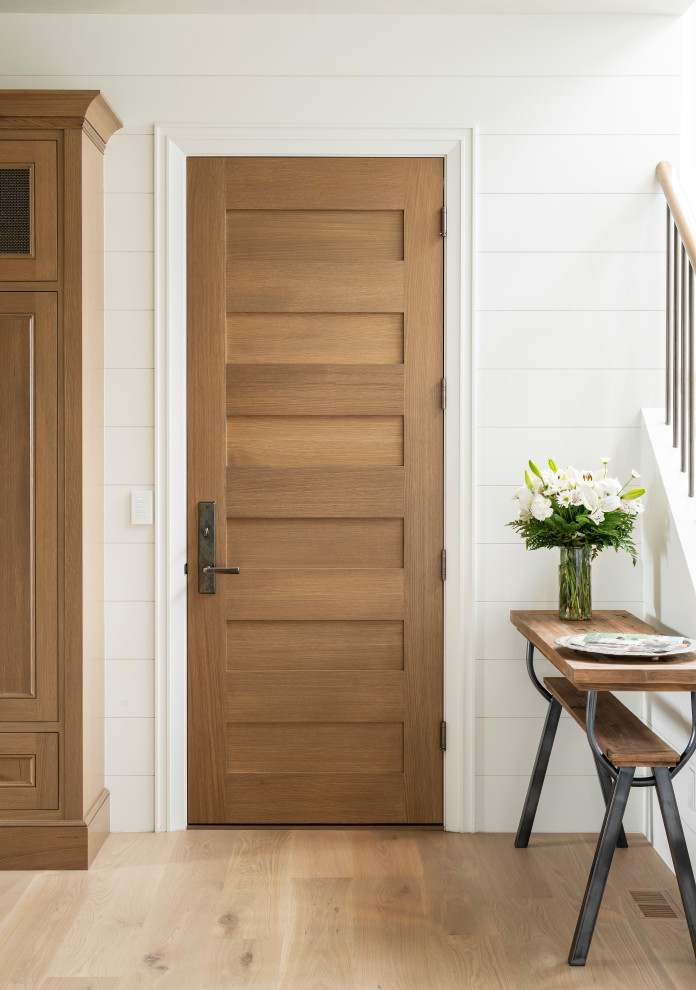 Ispirazione per un ampio ingresso con anticamera country con pareti bianche, parquet chiaro, una porta singola, una porta in legno bruno e pavimento beige