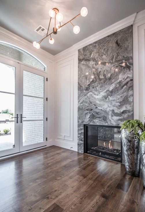 他の地域にある巨大なトランジショナルスタイルのおしゃれな玄関ロビー (白い壁、無垢フローリング、ガラスドア、茶色い床) の写真