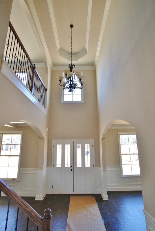 This is an example of an expansive modern foyer in Birmingham with dark hardwood flooring and a double front door.
