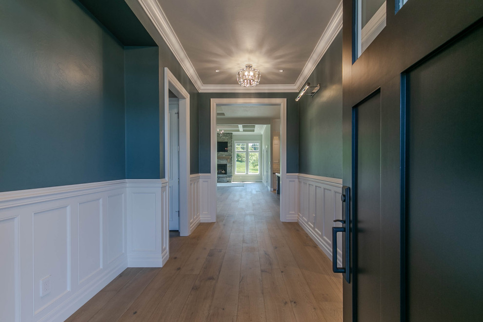 Großes Modernes Foyer mit bunten Wänden, braunem Holzboden, Einzeltür, schwarzer Haustür, grauem Boden, Kassettendecke und vertäfelten Wänden in Portland