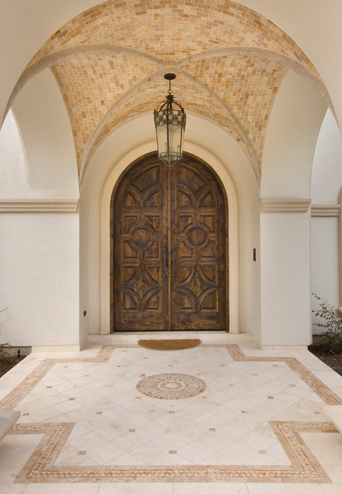 Mediterranean entrance in Houston with a double front door and a dark wood front door.