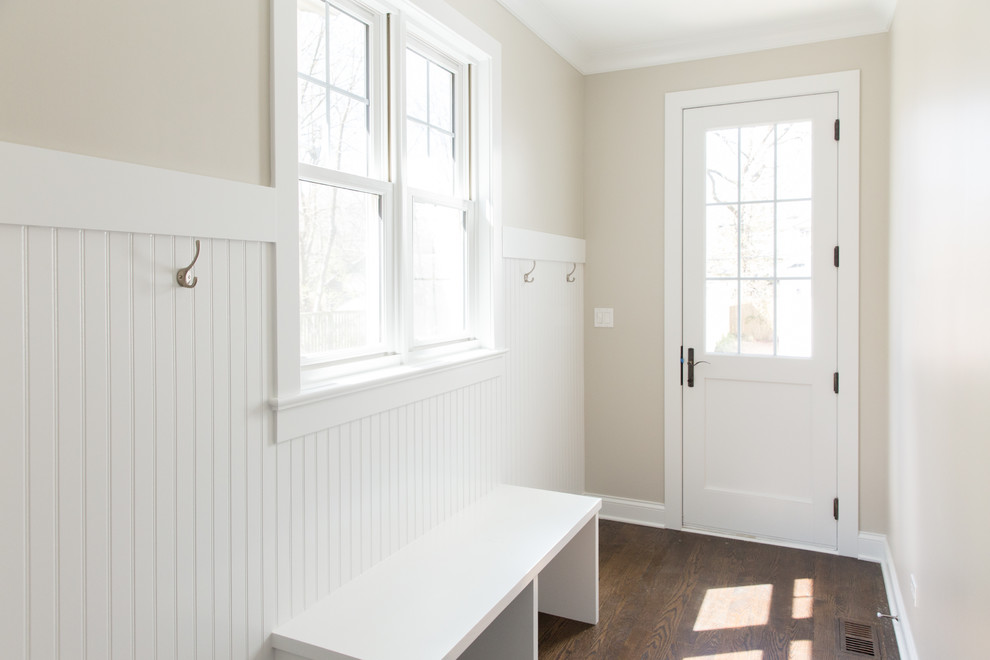 Idées déco pour une petite entrée classique avec un vestiaire, un mur beige, parquet foncé, une porte simple, une porte blanche et un sol marron.