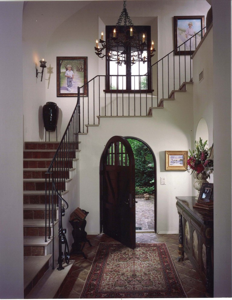 Пример оригинального дизайна: фойе в средиземноморском стиле с одностворчатой входной дверью и входной дверью из темного дерева