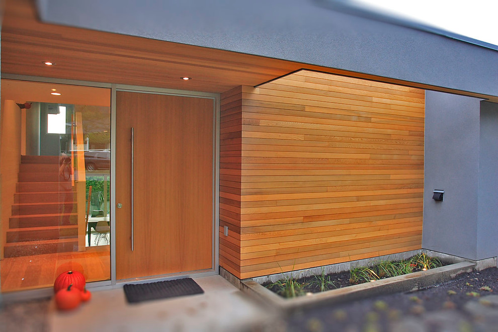 Photo of a modern entrance in Vancouver with a single front door and a medium wood front door.
