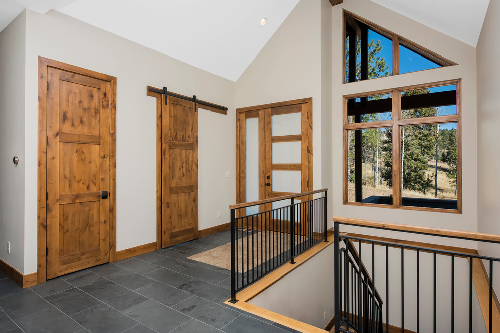 This is an example of a medium sized rustic foyer in Denver with beige walls, slate flooring, a single front door and a light wood front door.