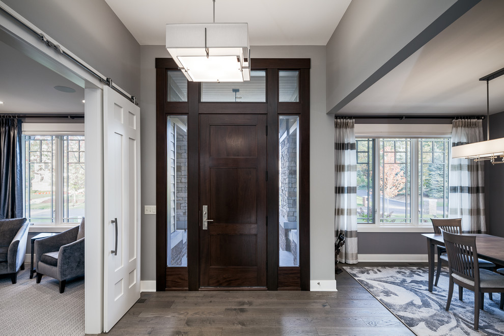 Mittelgroße Moderne Haustür mit grauer Wandfarbe, braunem Boden, Einzeltür, dunkler Holzhaustür und braunem Holzboden in Grand Rapids