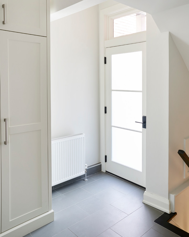 Immagine di un ingresso chic di medie dimensioni con pareti bianche, pavimento con piastrelle in ceramica, una porta singola e una porta bianca