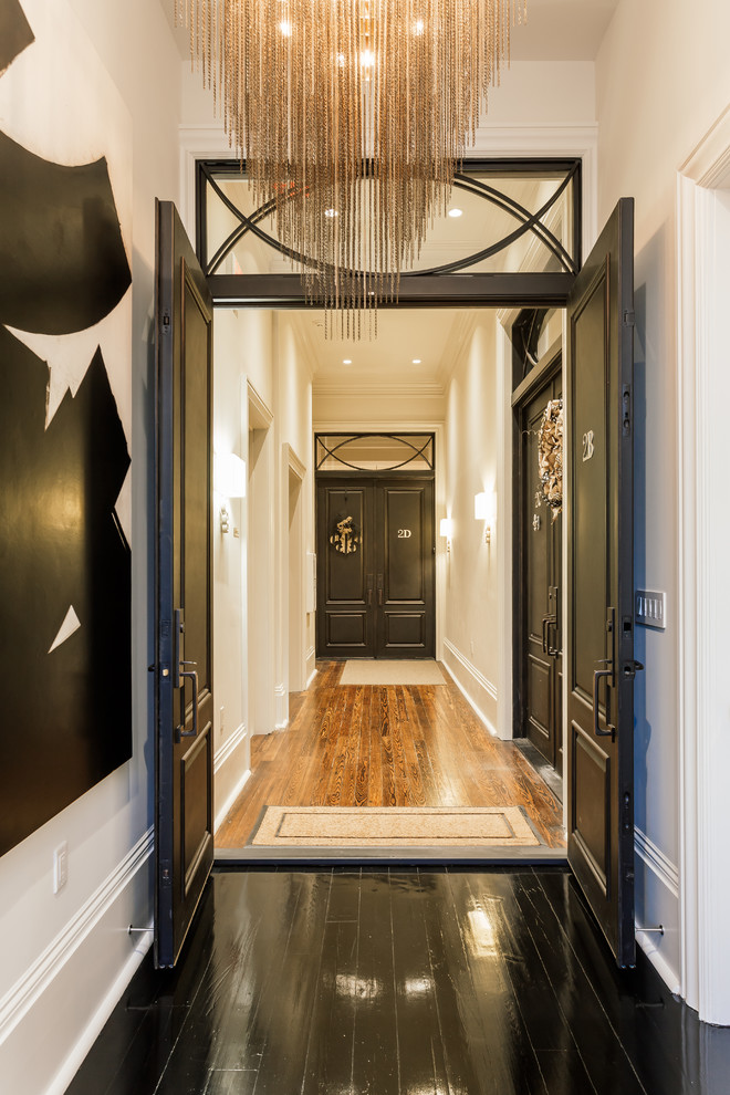 Immagine di un corridoio minimal di medie dimensioni con una porta a due ante, pareti bianche, pavimento in laminato, una porta nera e pavimento nero