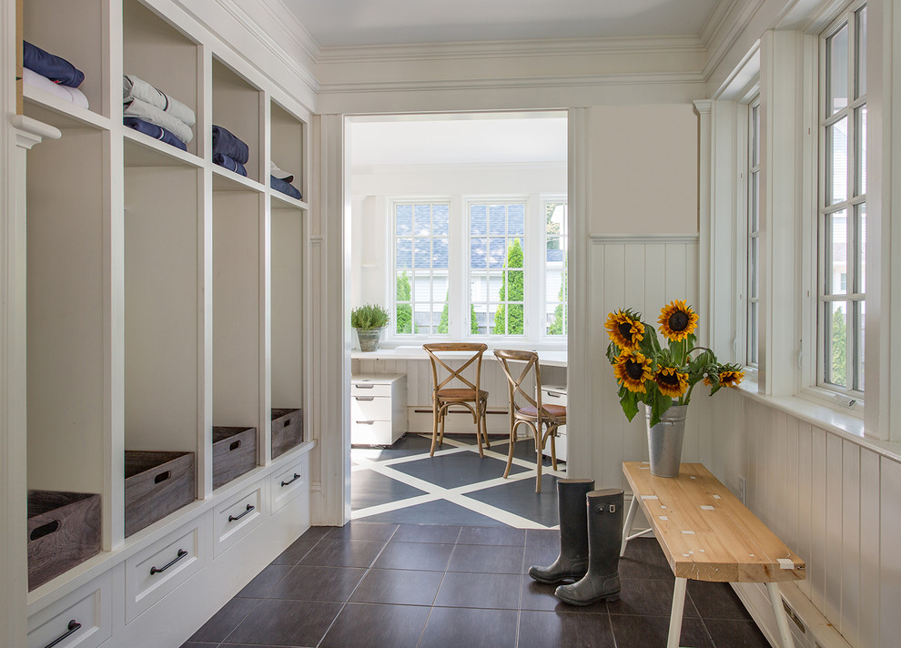 This is an example of a country boot room in Boston with white walls.