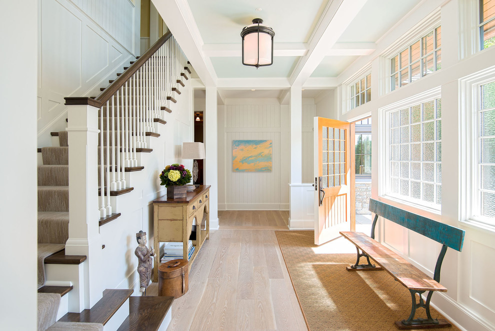Ispirazione per un corridoio tradizionale con pareti bianche, parquet chiaro, una porta singola, una porta gialla e pavimento beige