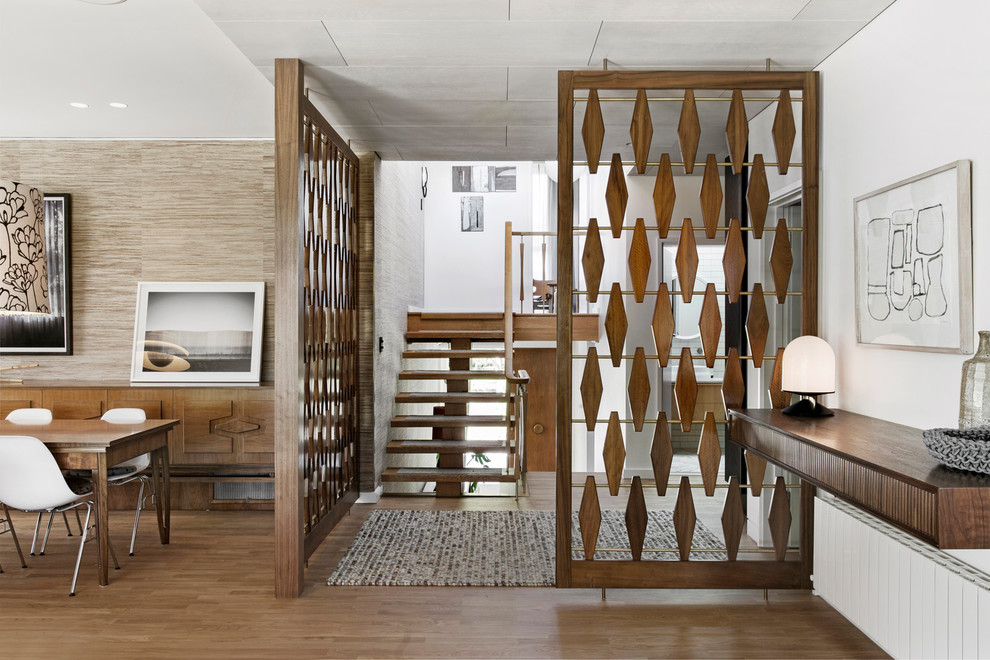 Esempio di una porta d'ingresso minimalista con pavimento in legno massello medio, pareti bianche e pavimento marrone