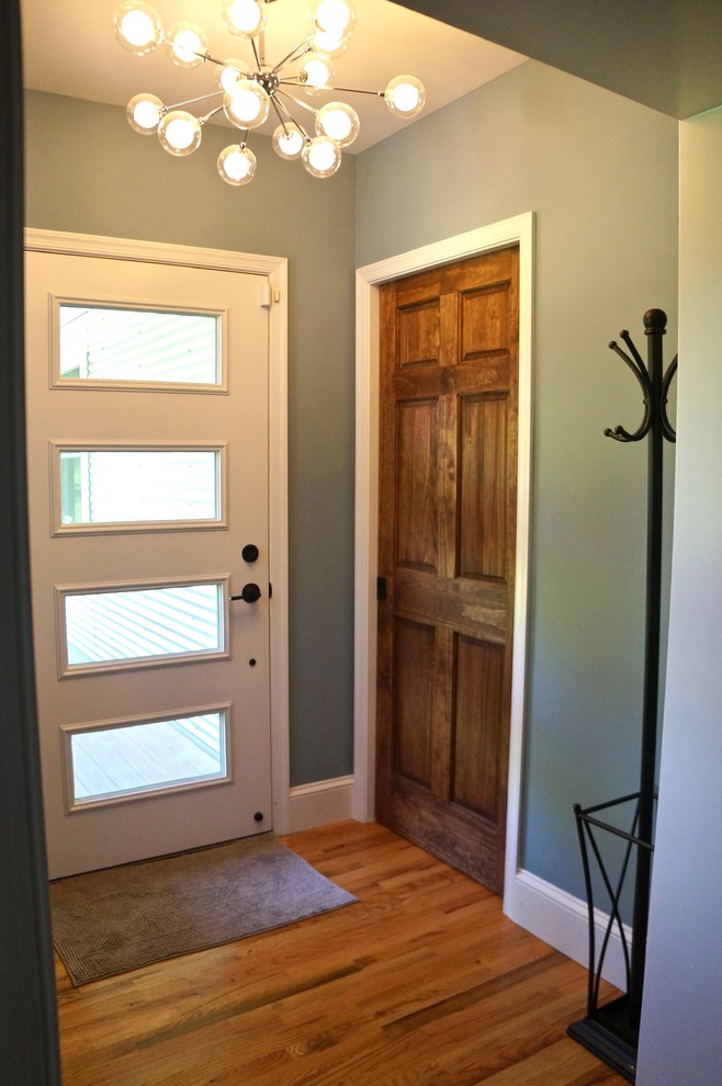 Стильный дизайн: маленькое фойе в стиле модернизм с синими стенами, паркетным полом среднего тона, одностворчатой входной дверью, зеленой входной дверью и коричневым полом для на участке и в саду - последний тренд