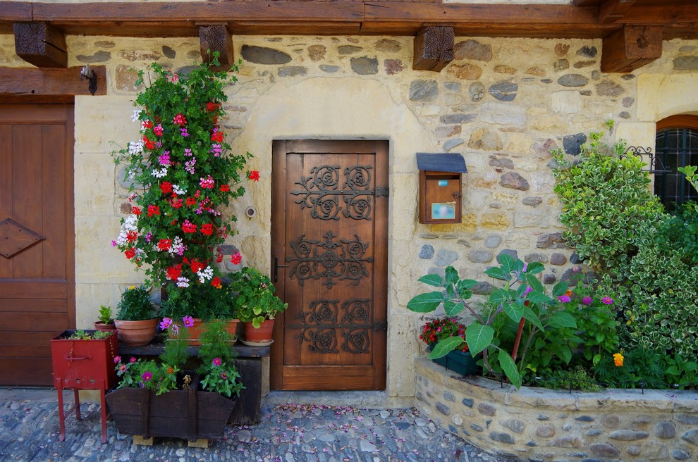 Idée de décoration pour une petite porte d'entrée avec un mur beige, une porte simple, une porte en bois brun et un sol multicolore.