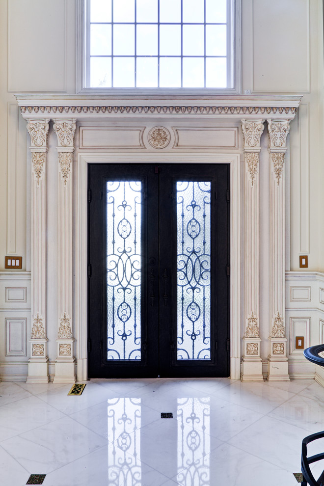 Klassisk inredning av en stor ingång och ytterdörr, med vita väggar, klinkergolv i porslin, en dubbeldörr, en svart dörr och vitt golv