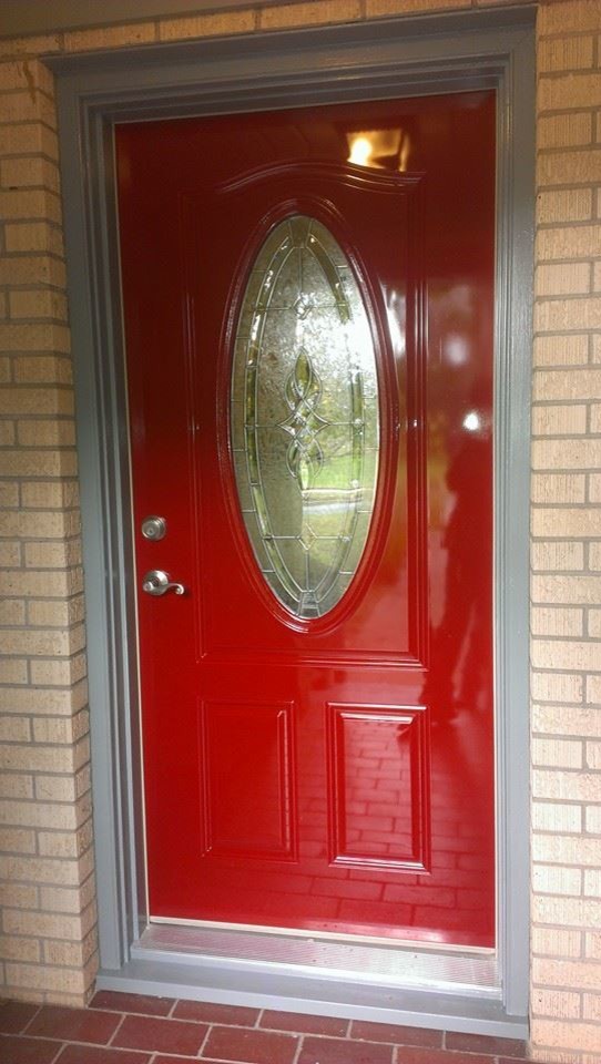 オースティンにある低価格のおしゃれな玄関 (ベージュの壁、レンガの床、赤いドア) の写真