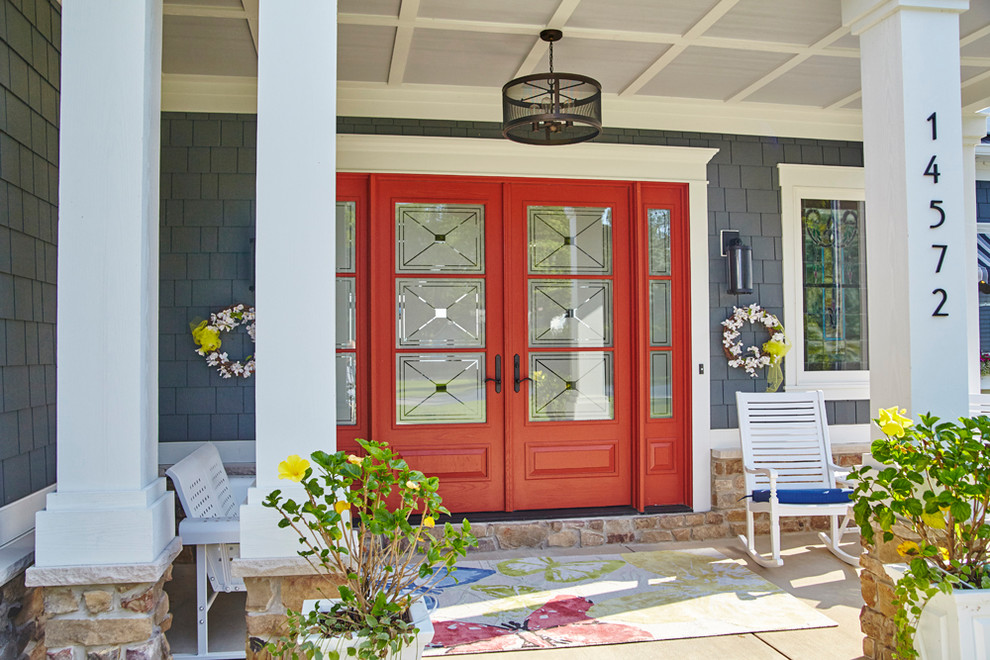 Bild på en mellanstor lantlig ingång och ytterdörr, med en dubbeldörr och en röd dörr