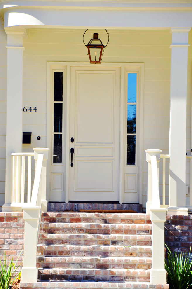 Modelo de puerta principal tradicional de tamaño medio con paredes beige, puerta simple y puerta blanca