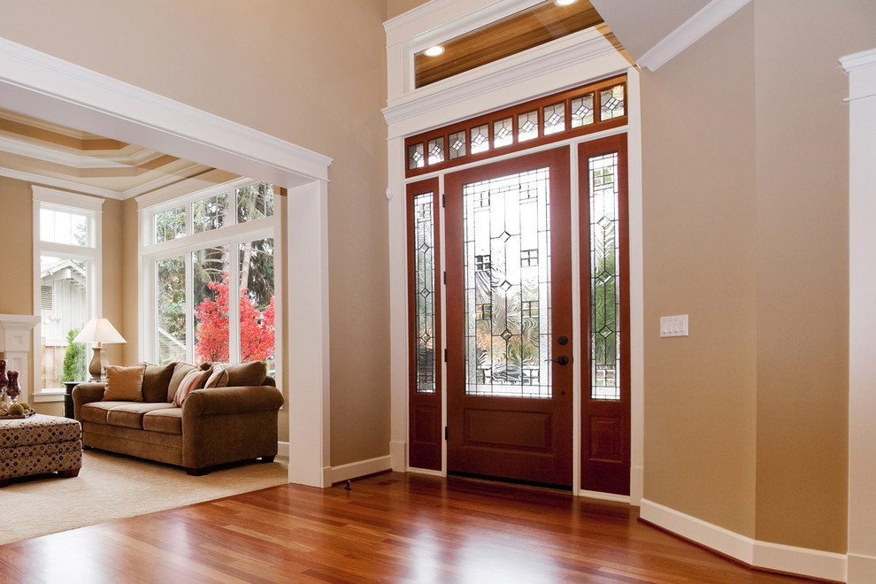 Example of a mid-sized classic medium tone wood floor entryway design in Baltimore with beige walls and a red front door