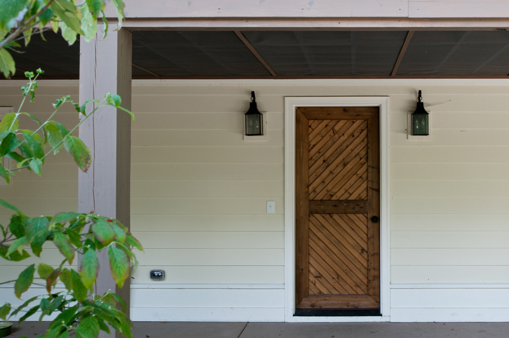 Immagine di una porta d'ingresso country con una porta singola e una porta in legno bruno