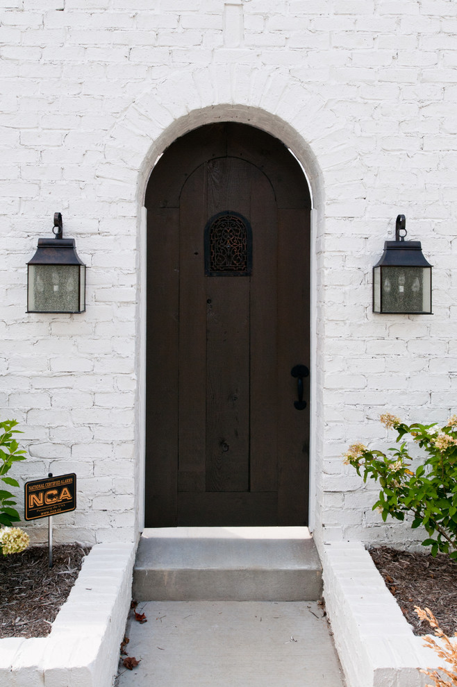 Источник вдохновения для домашнего уюта: прихожая в средиземноморском стиле с одностворчатой входной дверью и входной дверью из темного дерева