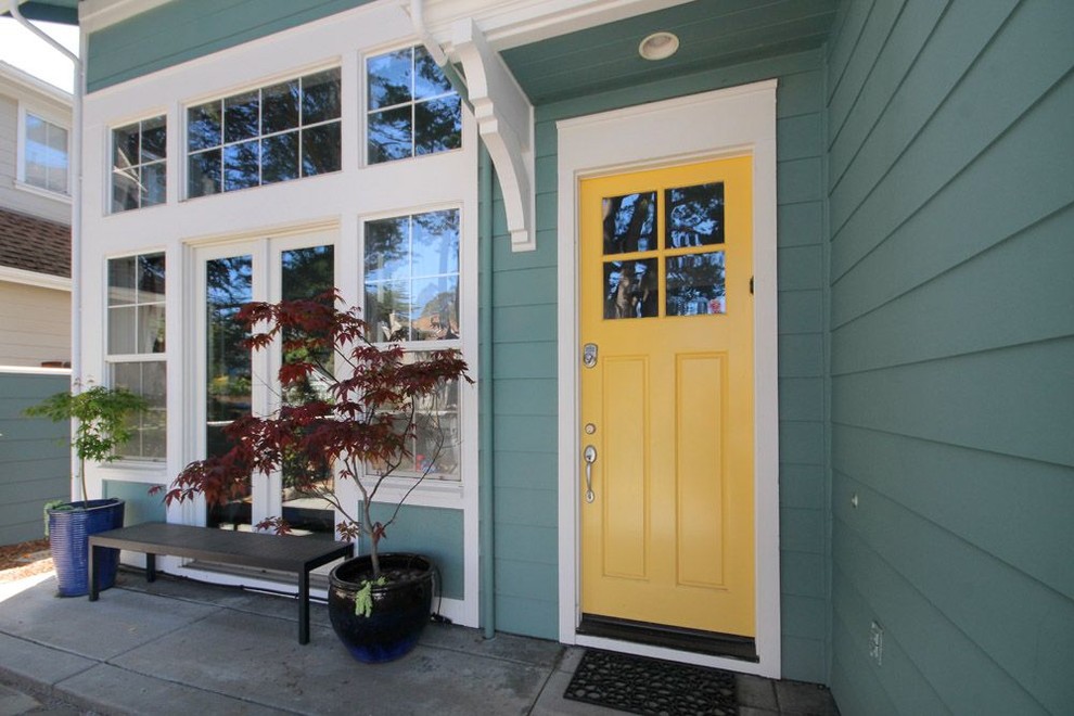 Стильный дизайн: входная дверь среднего размера в стиле неоклассика (современная классика) с зелеными стенами, одностворчатой входной дверью и желтой входной дверью - последний тренд