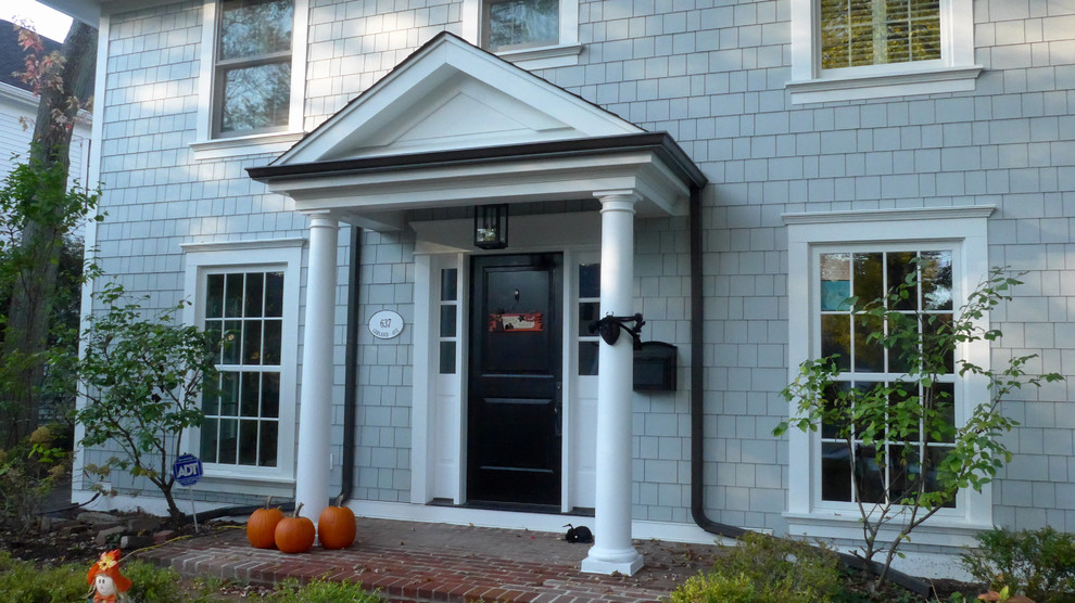 На фото: входная дверь среднего размера в классическом стиле с серыми стенами, кирпичным полом, одностворчатой входной дверью, черной входной дверью и красным полом с