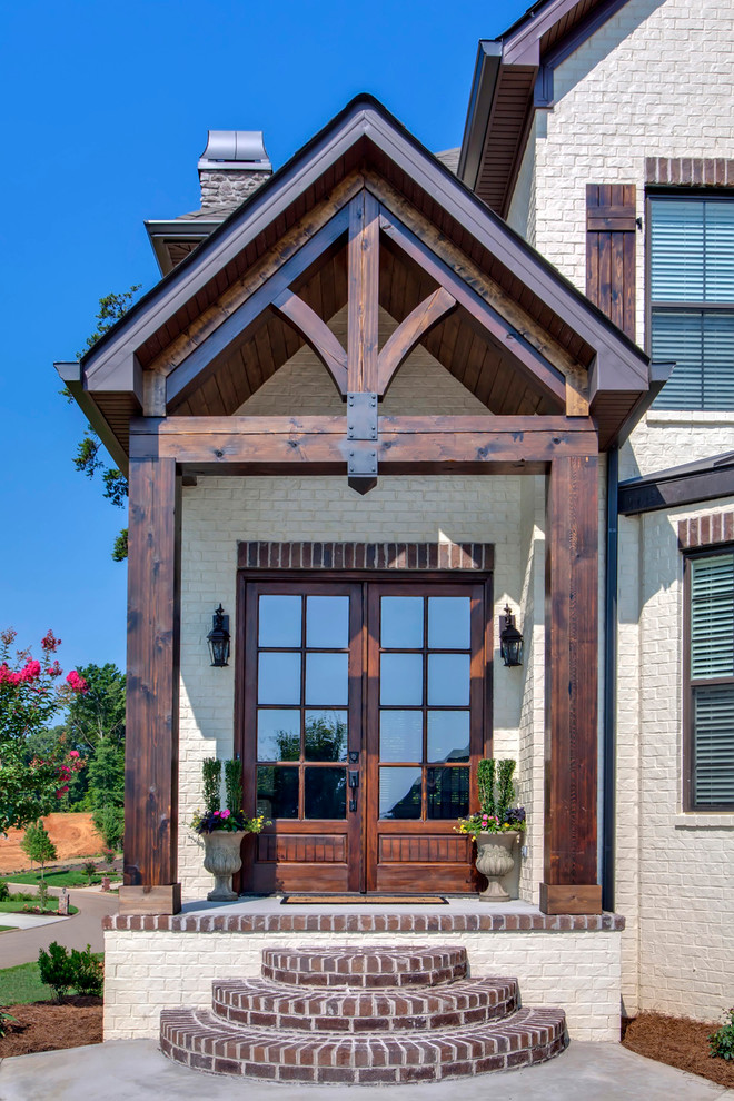 Aménagement d'une grande porte d'entrée classique avec une porte double et une porte en bois brun.