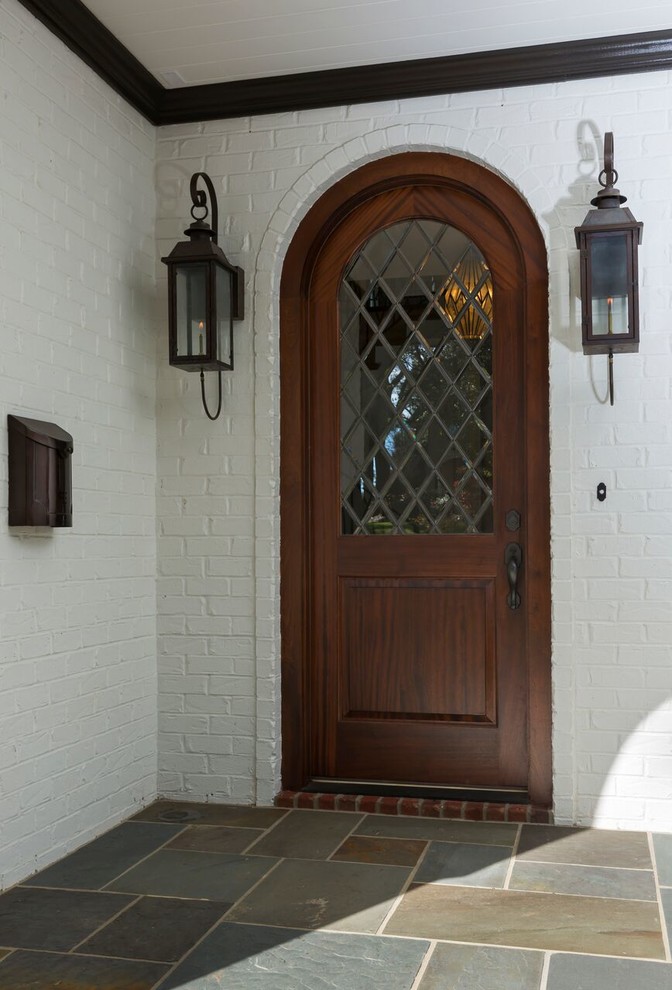 На фото: входная дверь среднего размера в классическом стиле с белыми стенами, гранитным полом, одностворчатой входной дверью и входной дверью из темного дерева с