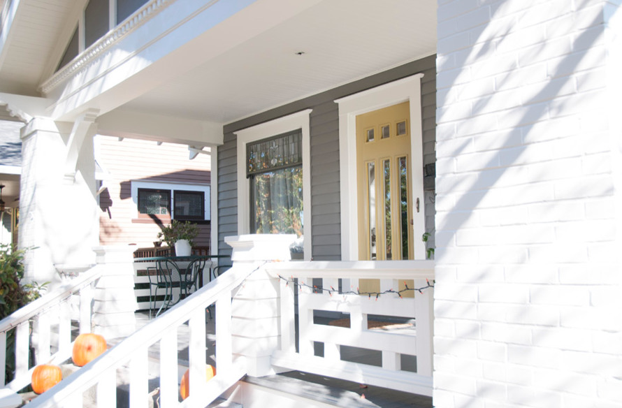 Idée de décoration pour une porte d'entrée craftsman de taille moyenne avec un mur gris, une porte simple et une porte jaune.