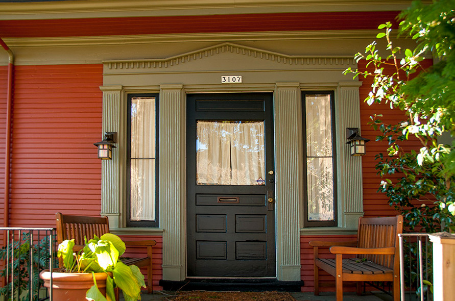 Inspiration pour une porte d'entrée traditionnelle de taille moyenne avec un mur rouge, une porte simple et une porte noire.