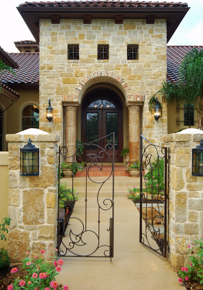 Inspiration for a large mediterranean entryway remodel in Austin with beige walls and a dark wood front door