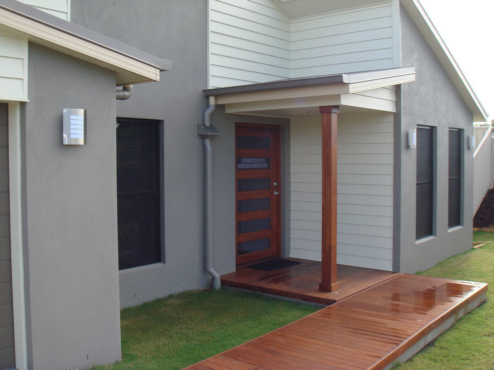Large modern front door in Brisbane with grey walls, medium hardwood flooring, a pivot front door and a dark wood front door.