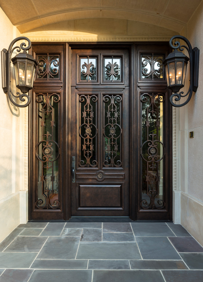 Imagen de puerta principal tradicional grande con paredes beige, puerta doble y puerta marrón