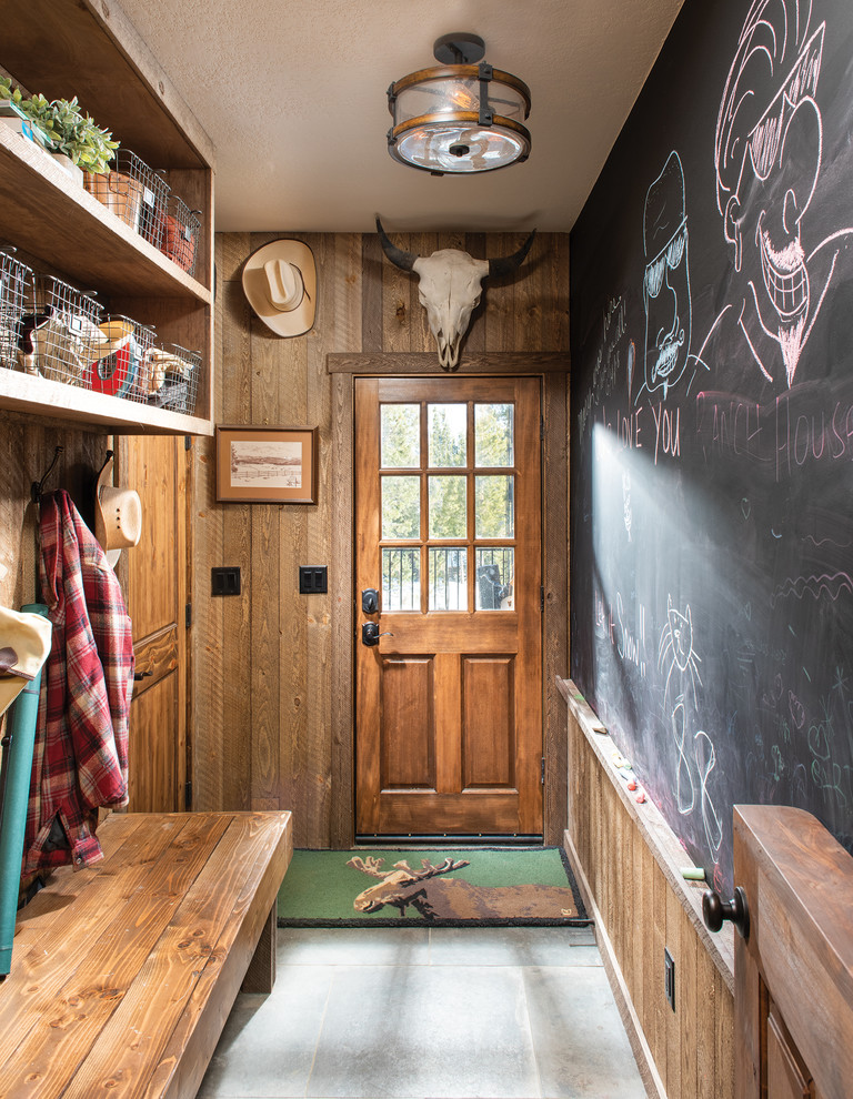 デンバーにあるラスティックスタイルのおしゃれなマッドルーム (黒い壁、木目調のドア、グレーの床) の写真