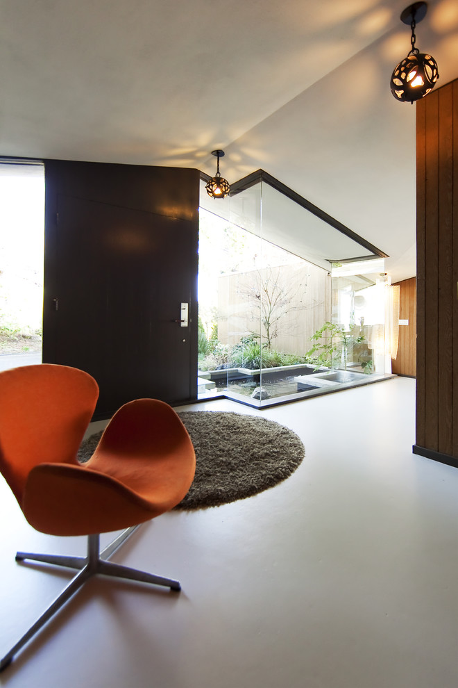 Entryway - mid-sized modern concrete floor entryway idea in Vancouver with a dark wood front door and white walls