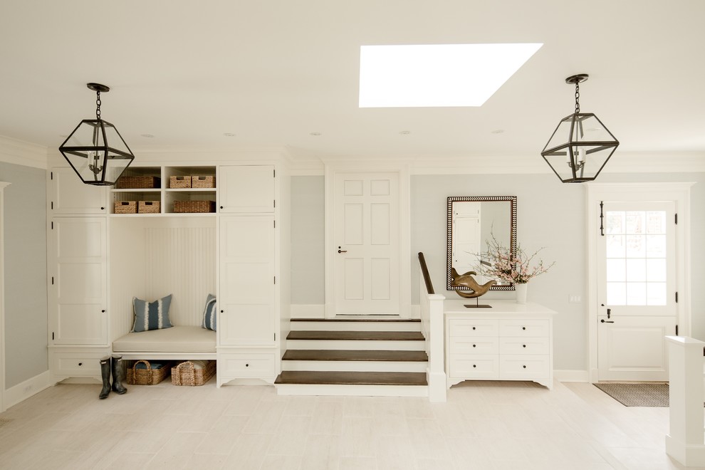 This is an example of a traditional boot room in New York with grey walls, a single front door and a white front door.
