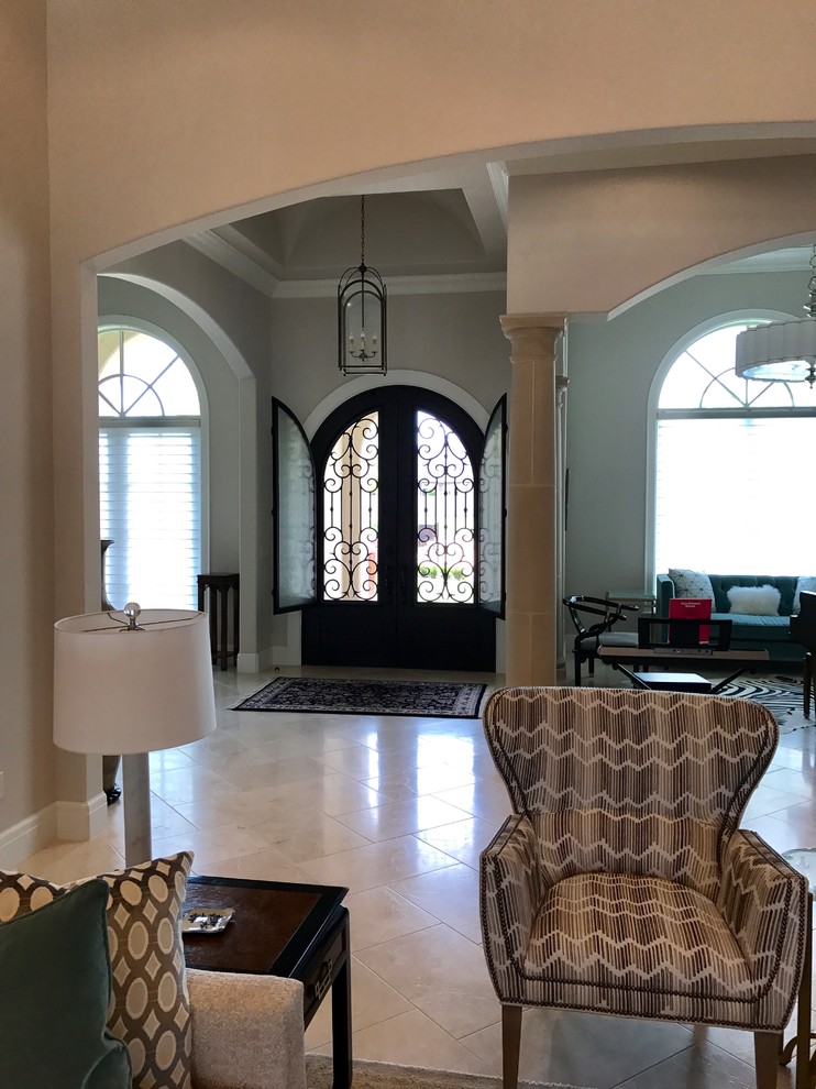 This is an example of a medium sized classic front door in Oklahoma City with beige walls, travertine flooring, a double front door and beige floors.