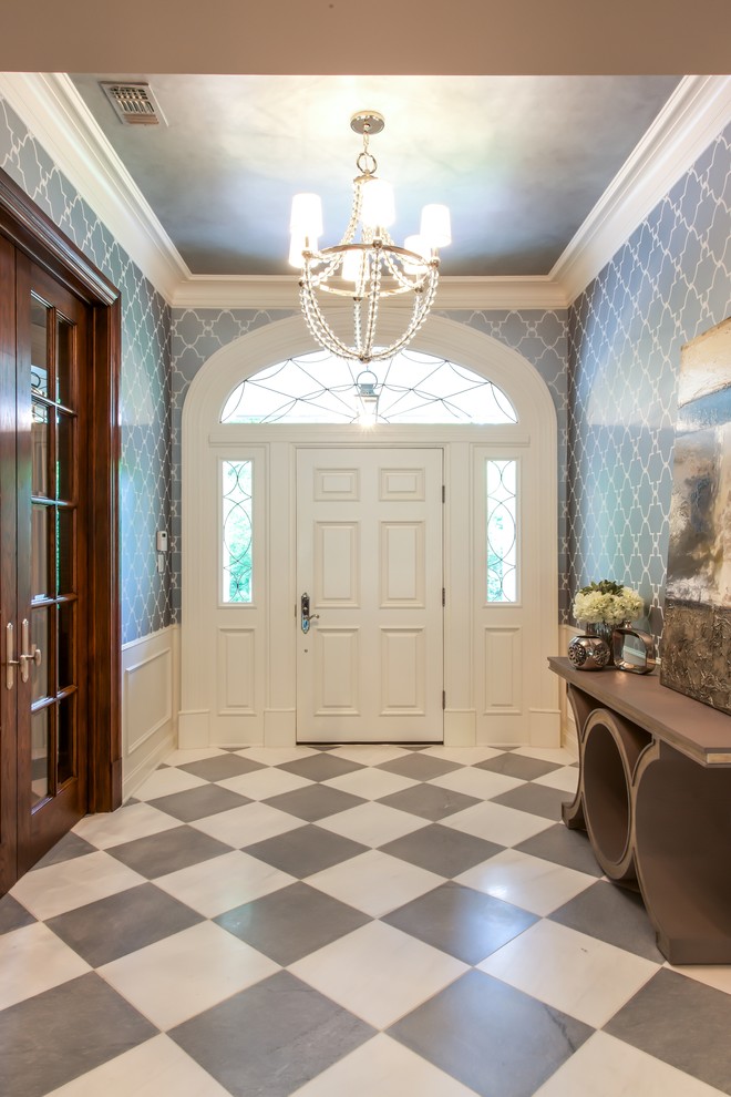 ダラスにあるラグジュアリーな巨大なトランジショナルスタイルのおしゃれな玄関ロビー (グレーの壁、大理石の床、白いドア、マルチカラーの床) の写真