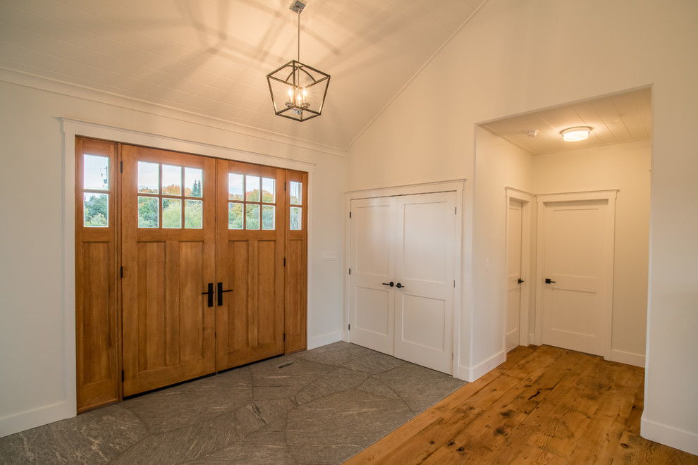 Ispirazione per una porta d'ingresso stile rurale di medie dimensioni con pareti bianche, pavimento in ardesia, una porta a due ante e una porta in legno chiaro