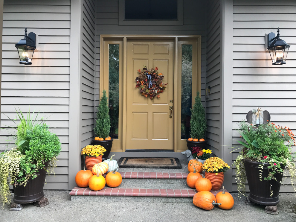 На фото: входная дверь среднего размера в классическом стиле с коричневыми стенами, кирпичным полом, одностворчатой входной дверью, желтой входной дверью и серым полом с
