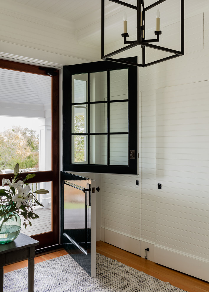 Стильный дизайн: фойе в морском стиле с белыми стенами, паркетным полом среднего тона, голландской входной дверью, черной входной дверью и коричневым полом - последний тренд