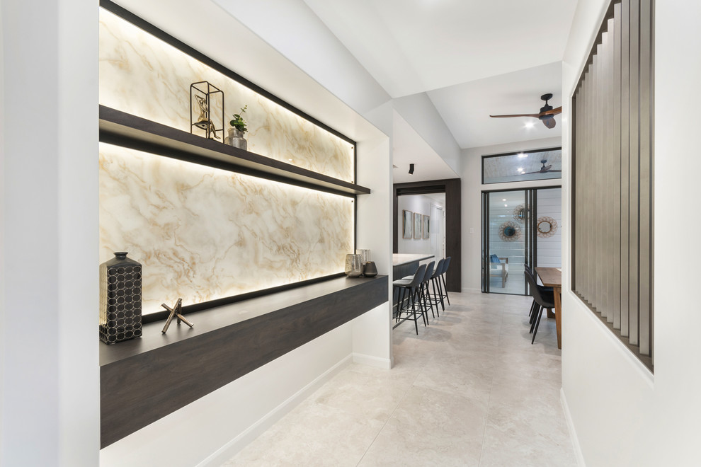 This is an example of a large modern foyer in Townsville with white walls, ceramic flooring and beige floors.